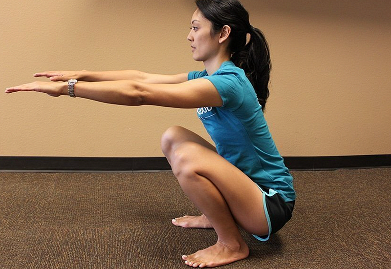 Individual performing a deep squat for strength